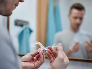 A young man preparing an over-the-counter teeth whitening tray