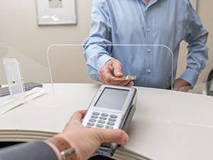 A man using a credit card to pay for dental care