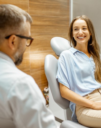 Woman in dental chair smiling at dentist