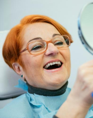 A senior woman smiling at her new dentures