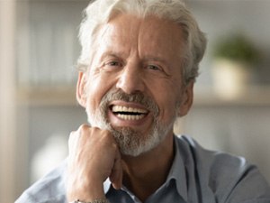 An elderly man with a candid, wide smile