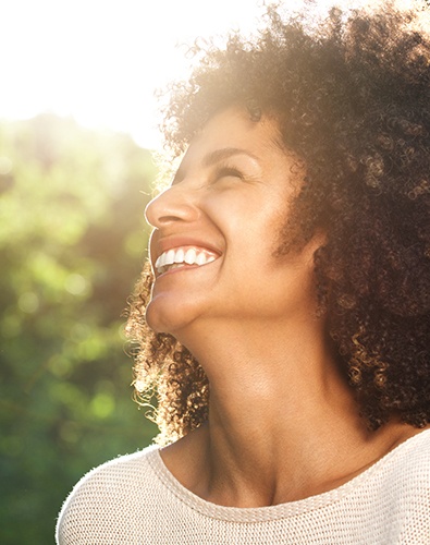 Woman smiling after receiving porcelain veneers