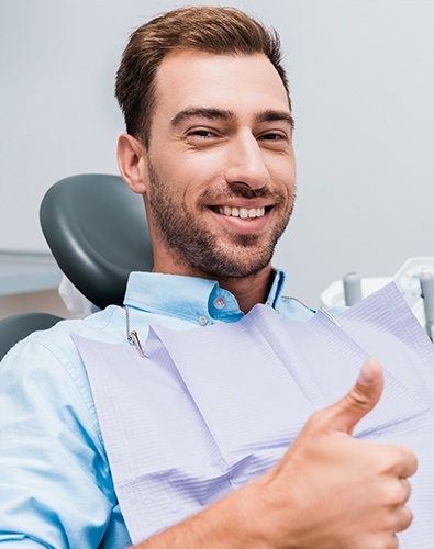 Man in dental chair giving thumbs up