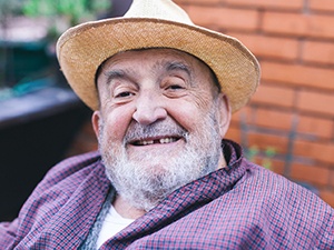 Senior man sitting outside with a missing tooth