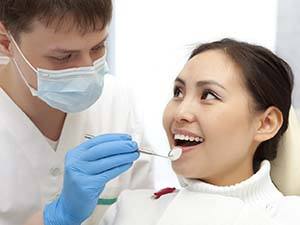 Woman smiles during her routine dental checkup from her dentist