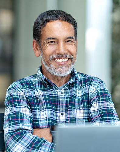 Smiling man looking at a laptop computer