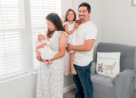 Doctor Aguilar smiling with his wife and daughter