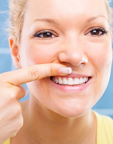 Woman looking at smile after gum disease treatment