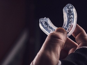 man holding up a mouthguard