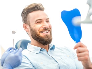 man smiling after getting dental implants in Denton