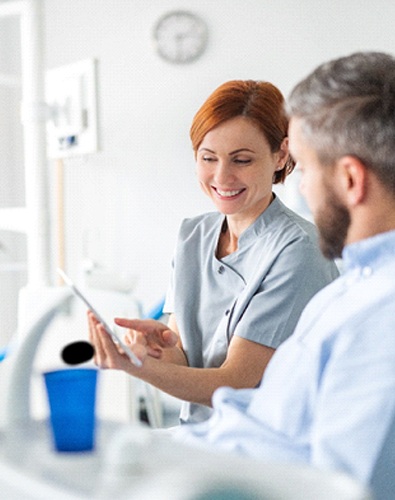 dentist and patient discussing implant dentures in Denton