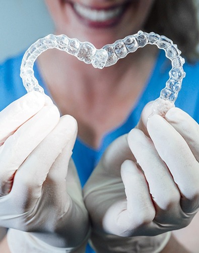 dentist forming heart with Invisalign aligners