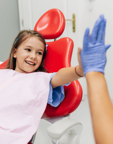 Young girl giving dentist a high five after children's dentistry