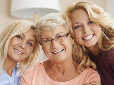 Three generations of women sharing healthy smiles after preventive dentistry