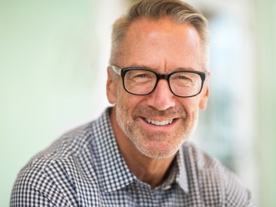 Man smiling after replacing missing teeth