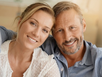 Man and woman with healthy smiles after periodontal therapy