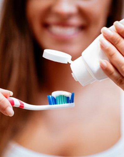 Woman holding toothbrush and toothpaste
