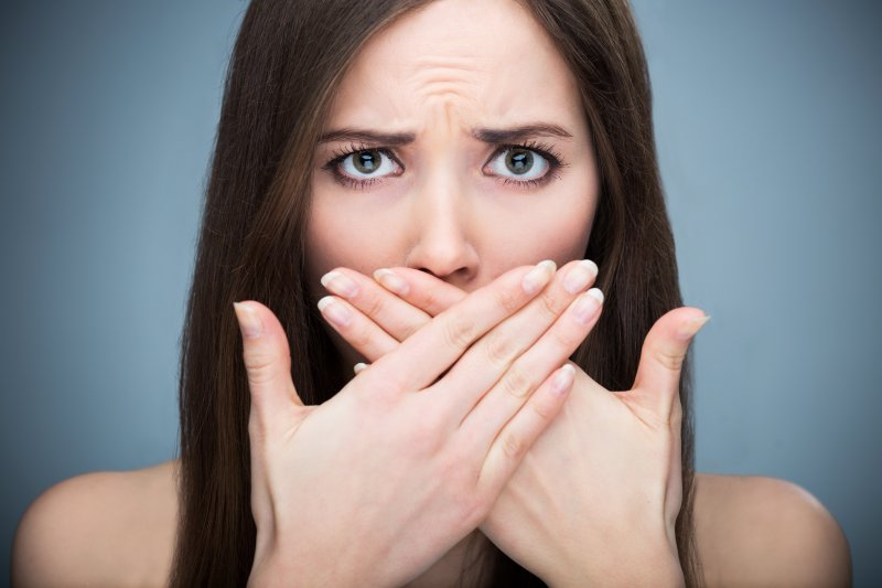 Woman covering gray teeth