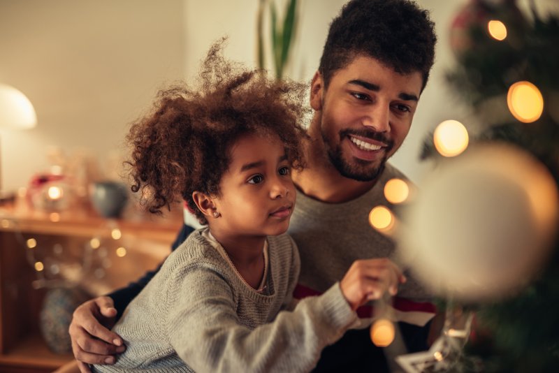 father and daughter decorating Christmas tree