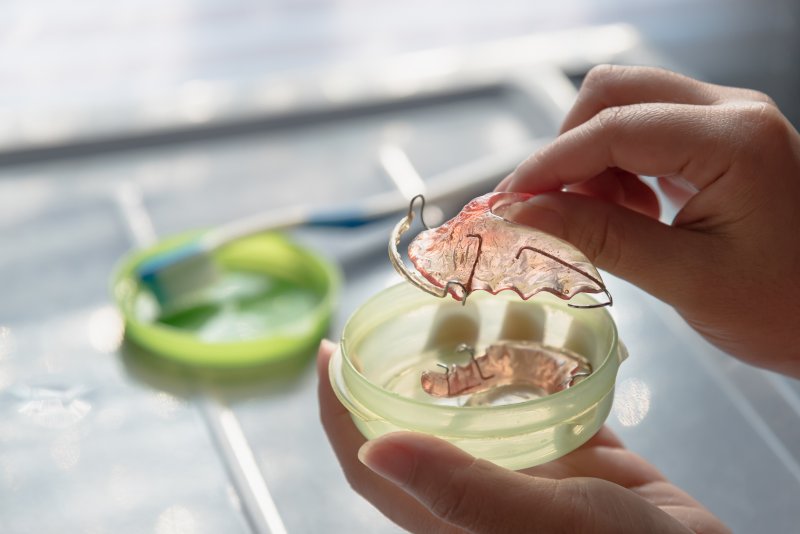 woman holding Invisalign retainer