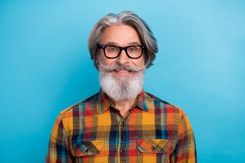 mature man smiling with implant dentures 