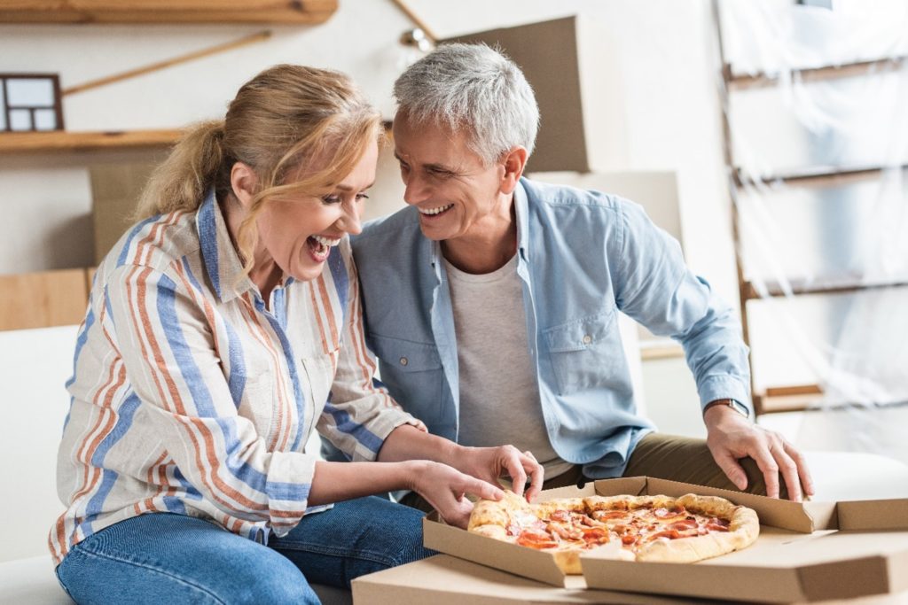 Couple with dentures eating a pizza.