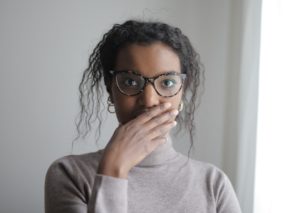 Young woman with her hand over her mouth