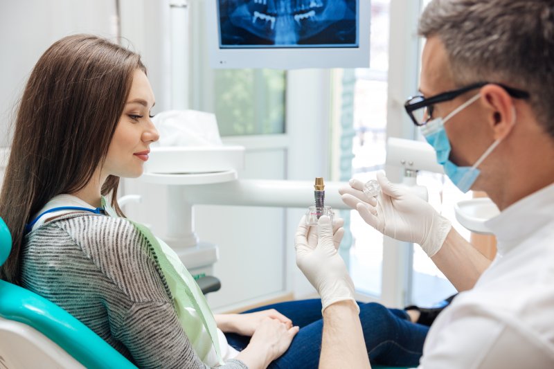 A dentist explaining the cosmetic benefits of dental implants