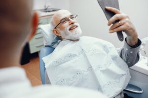 Man smiling with implant dentures